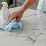 Young female professional cleaner wiping off table 